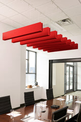 Red felt acoustic beams suspended from drop ceiling in conference room above meeting table.