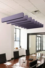 Purple felt acoustic beams suspended from ceiling above conference table in office space.