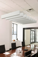 White felt acoustic beams suspended horizontally from ceiling above conference table in office space.