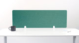 Teal desk divider with geometric arc pattern, mounted on white desk with supports.
