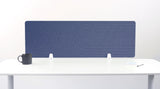 Blue desk divider with geometric line patterns, standing on white desk with black mug and white supports visible.