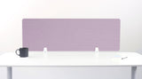 Purple desk divider with geometric line pattern mounted on white desk with small supports.