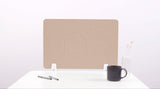 Beige desk divider with wave cutout design, displayed on white desk with small base supports.