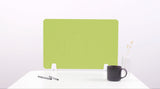 Lime green desk divider with wavy cutout design, positioned upright on white desk surface.
