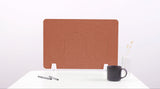 Terracotta desk divider with wavy cutouts and white base supports, displayed on white desk with mug and pens.