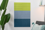 Wall-mounted organizer with lime green, gray, and teal fabric-covered compartments arranged in a grid pattern.