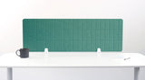 Teal grid desk divider with vertical panel segments mounted on white desk with black mug and papers.