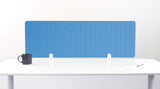 Blue grid desk divider with white mounting brackets on white desk surface.