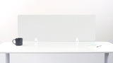 Clear acrylic grid desk divider with white mounting brackets on white desk surface.