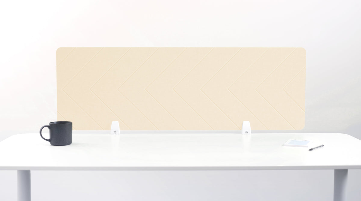 An ivory-colored felt desk divider placed on a white desk with a black mug and a pen beside it.