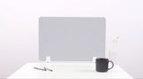 Gray desk divider with chevron pattern standing on white desk surface next to pens, mug, and vase.
