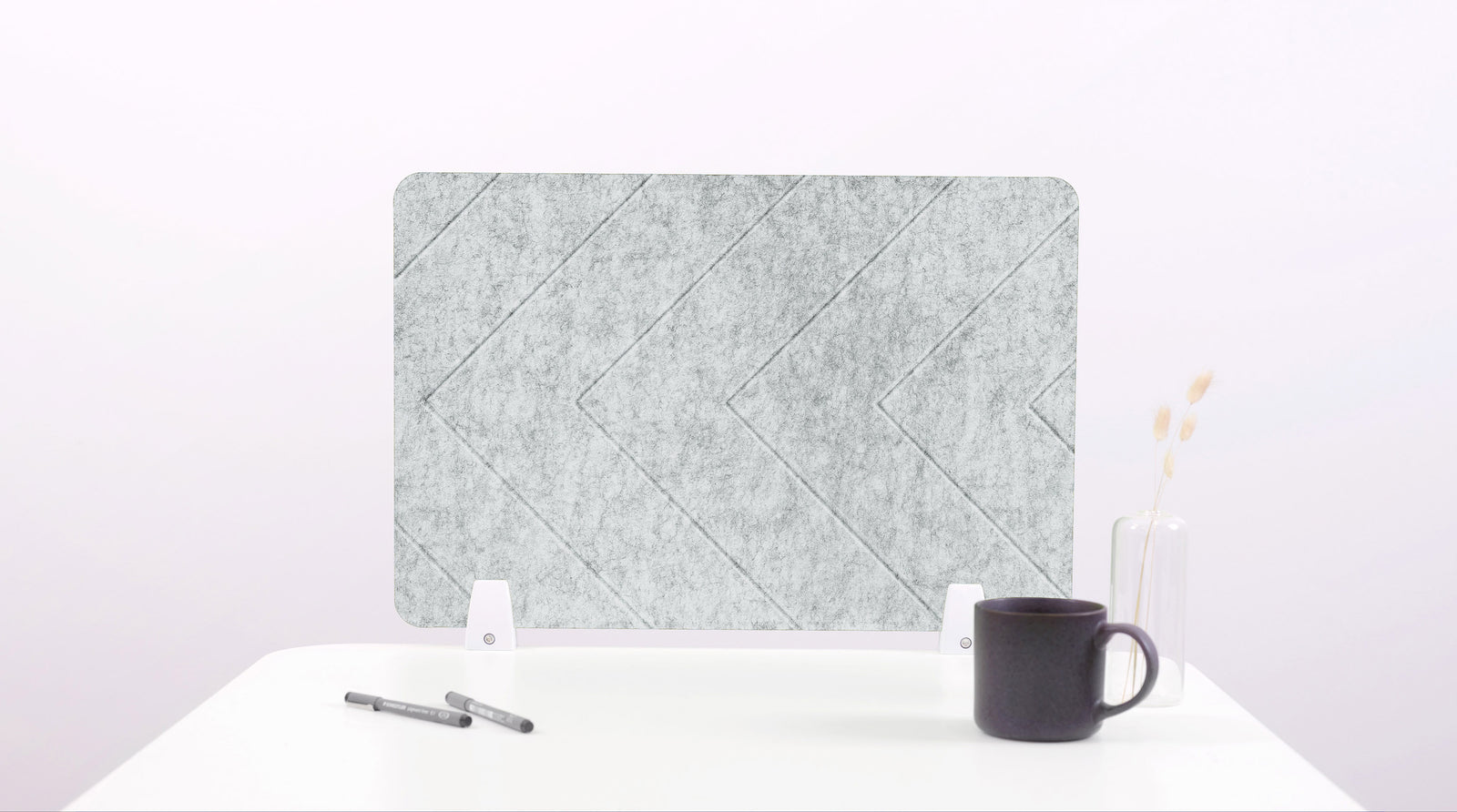 Felt screen protector on a white surface with a pen and mug