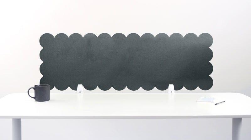 Scalloped black screen partition behind a white desk with a mug on a white background