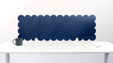 Scallop-shaped blue screen partition on a white desk with a mug and pen.