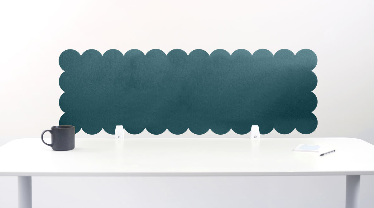 Scalloped black screen partition behind a white desk with a mug on a white background