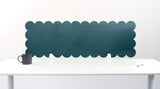 Scalloped black screen partition behind a white desk with a mug on a white background
