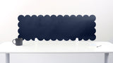 Scalloped black screen partition behind a white desk with a mug on a white background