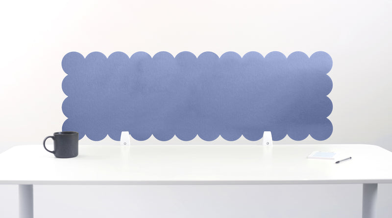 Scallop-shaped blue screen partition behind a white desk with a black mug on a white background