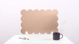 Brown cloud-shaped screen on a white surface with a black mug and pen.