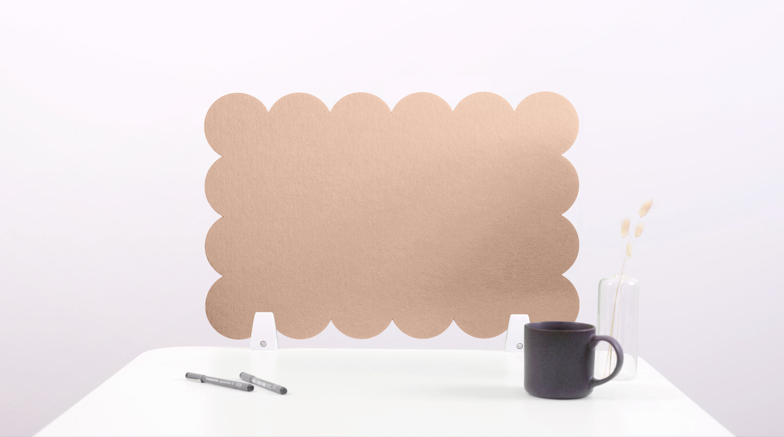 Brown cloud-shaped screen on a white surface with a black mug and pen.
