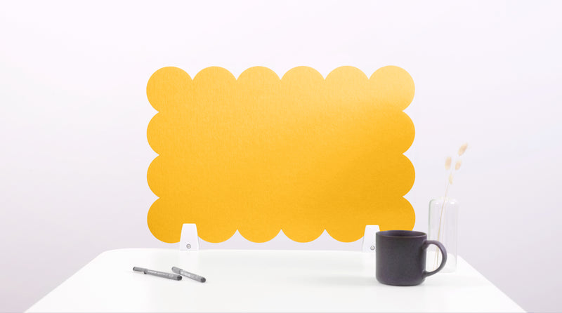 Yellow scalloped screen on a white surface with a black mug and pen holder.