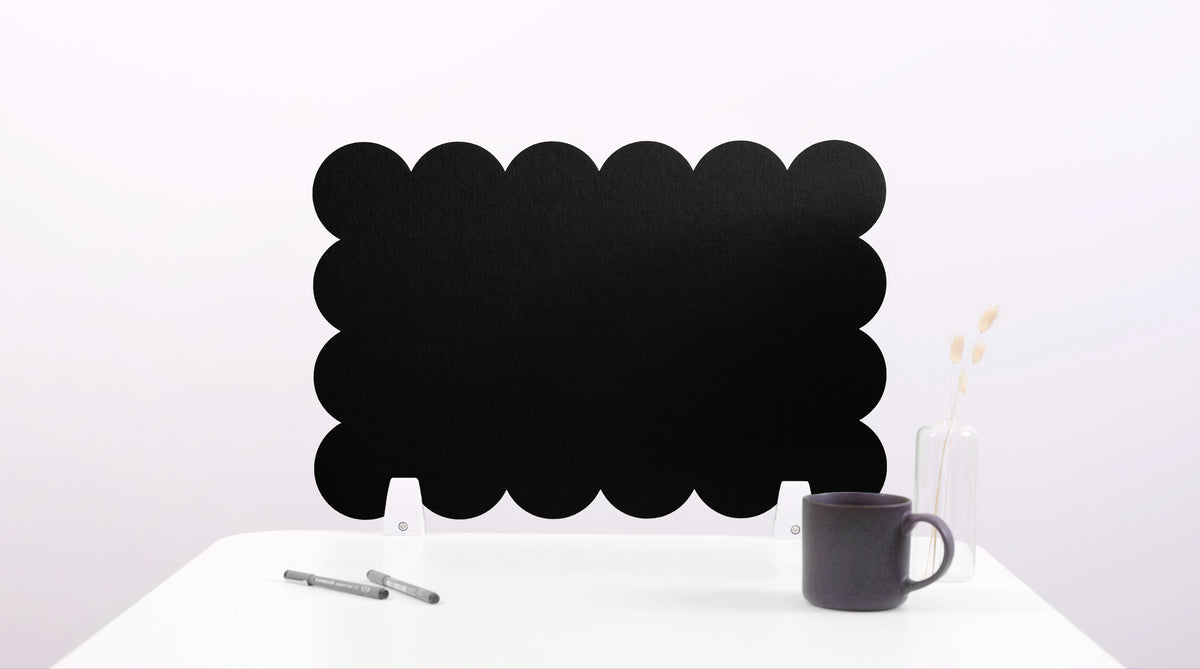 Black cloud-shaped chalkboard on a white surface with a pen and mug.