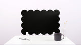 Black cloud-shaped chalkboard on a white surface with a pen and mug.