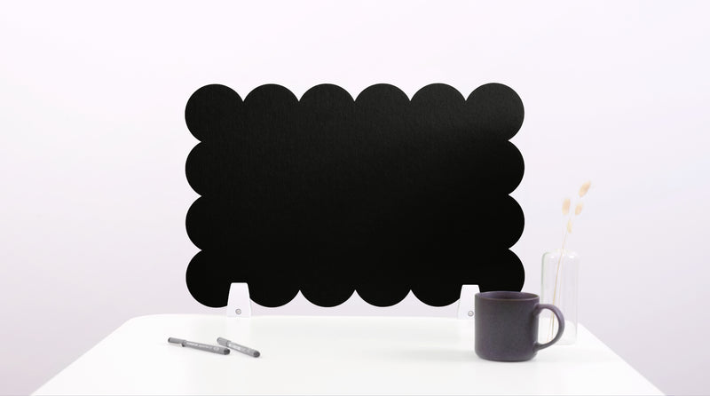 Black cloud-shaped chalkboard on a white surface with a pen and mug.