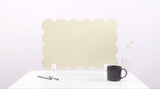 Beige cloud-shaped placemat on a white surface with a black mug and pen.