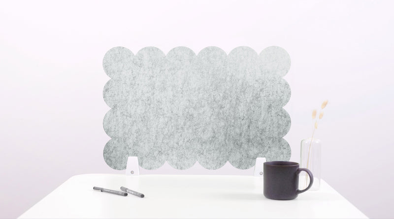 Decorative wall panel with scalloped edge on a white surface with a black mug and pen.