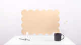 Beige cloud-shaped desk organizer on a white surface with a black mug and pen.