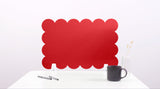 Red scalloped office screen on a white background with a black mug and pen.