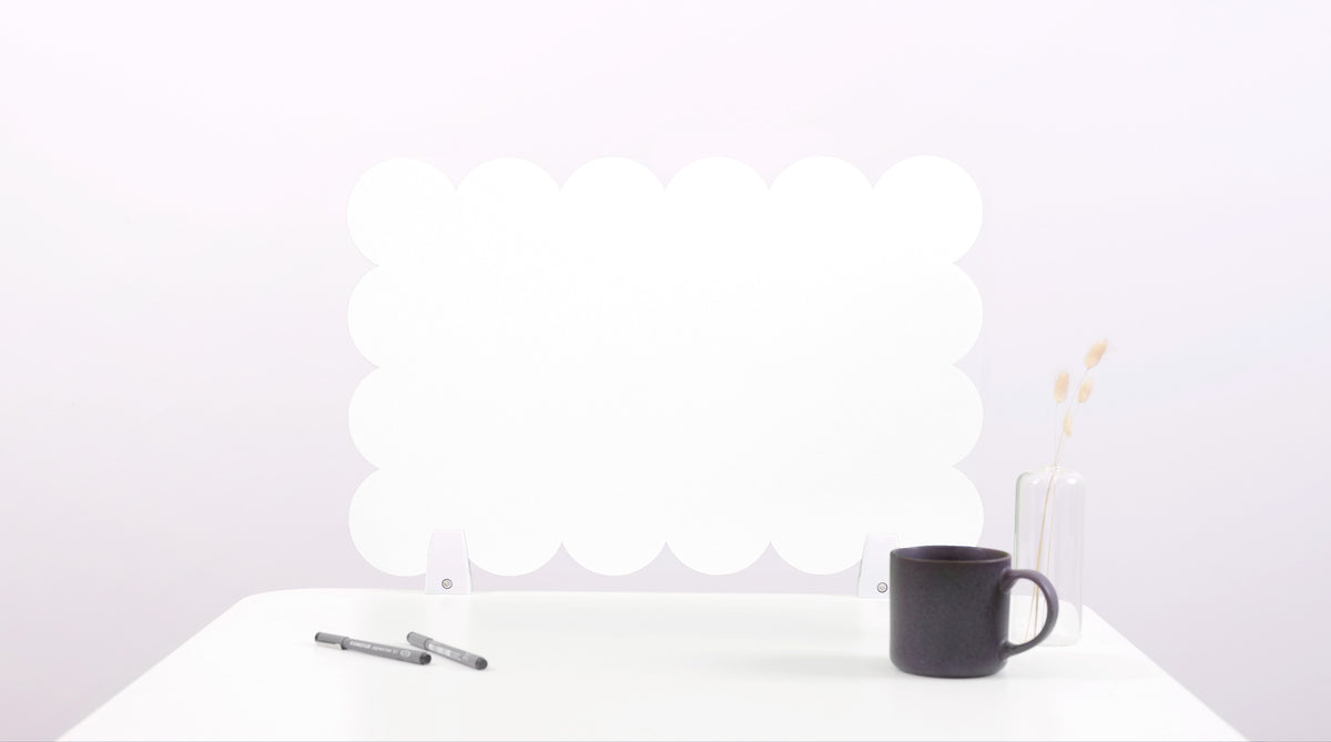 Black mug on a white surface with a white cloud-like object in the background
