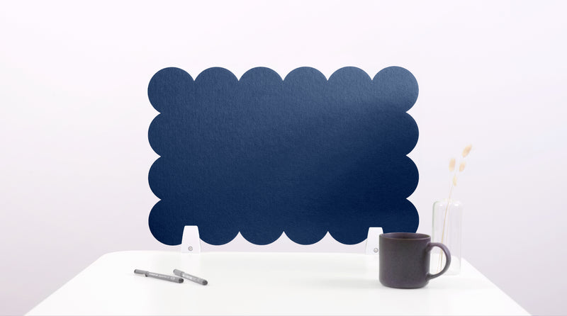 Navy blue scalloped edge screen on a white surface with a pen and mug.