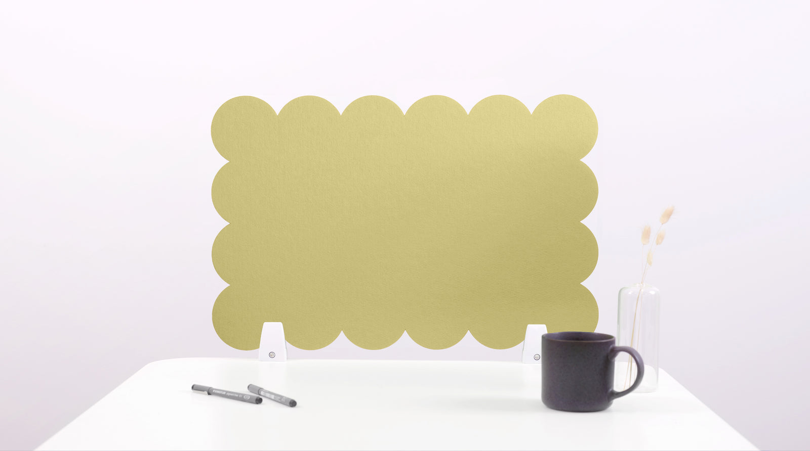 Gold decorative screen on a white surface with a black mug and pen.