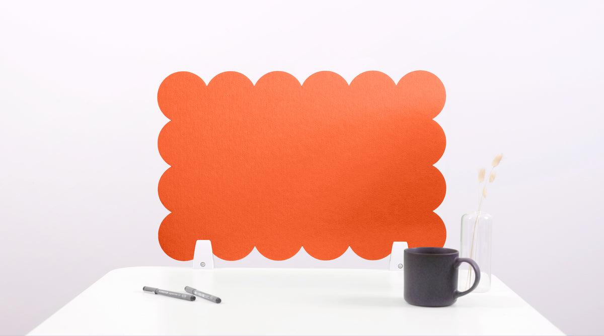 Orange scalloped headboard on a white background with a black mug and pen.
