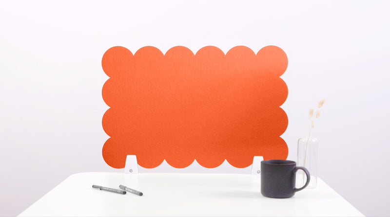 Orange scalloped headboard on a white background with a black mug and pen.