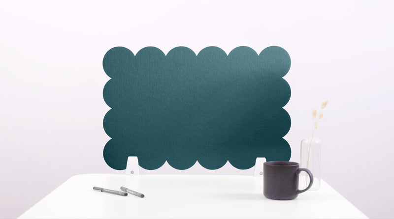 Navy blue scalloped edge screen on a white surface with a pen and mug.