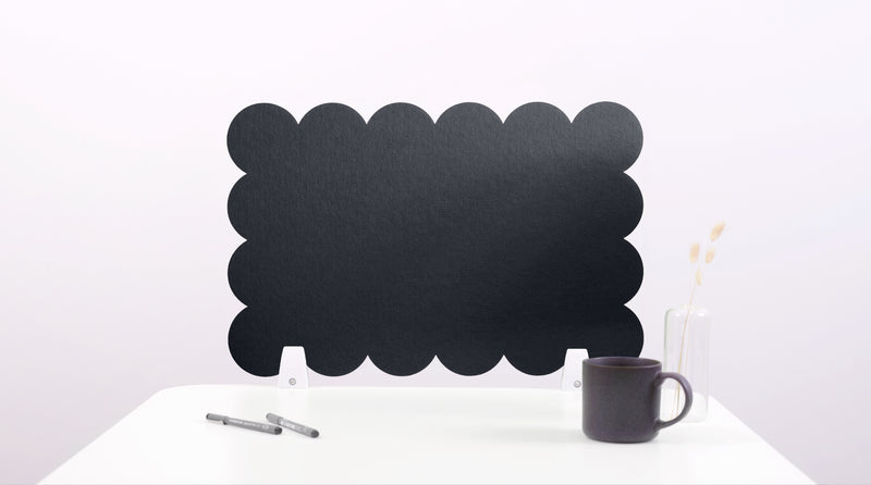 Black cloud-shaped chalkboard on a white surface with a pen and mug.
