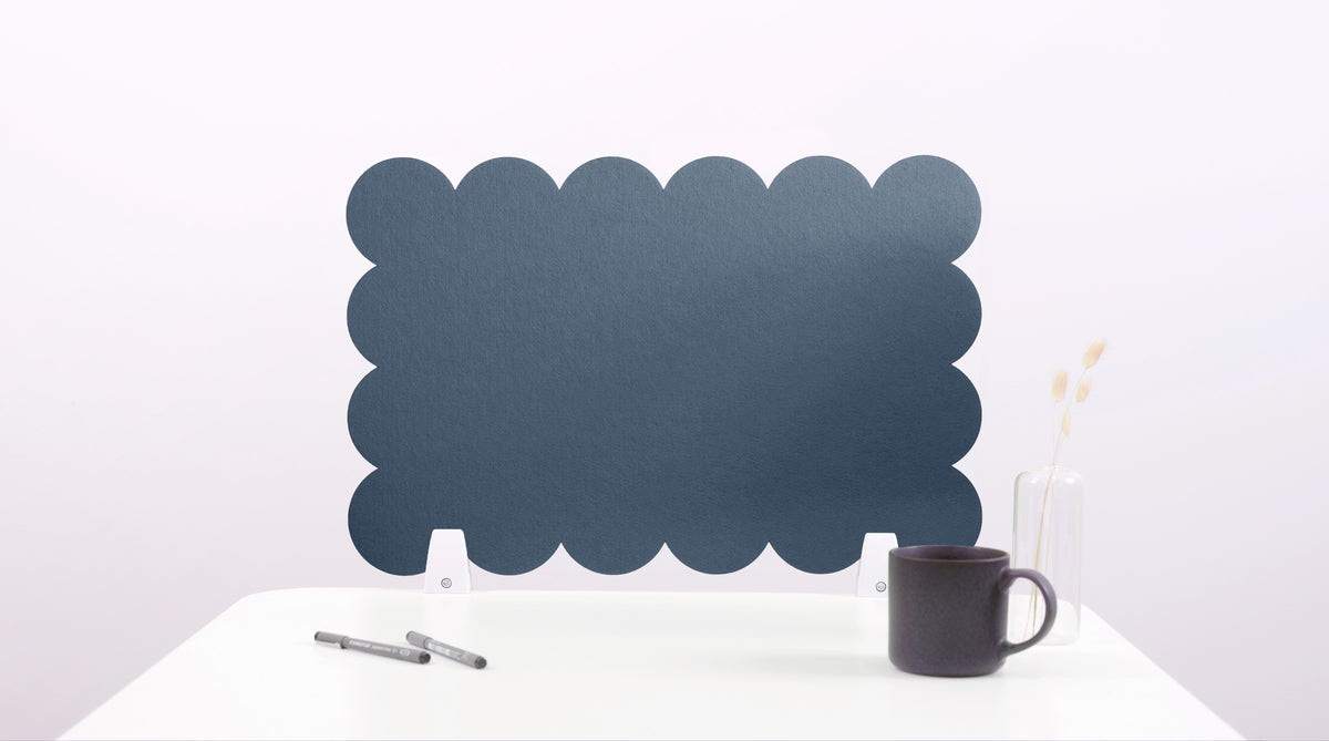 Black cloud-shaped desk divider on a white surface with a mug and pen.