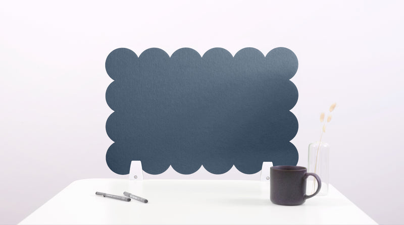 Black cloud-shaped desk divider on a white surface with a mug and pen.