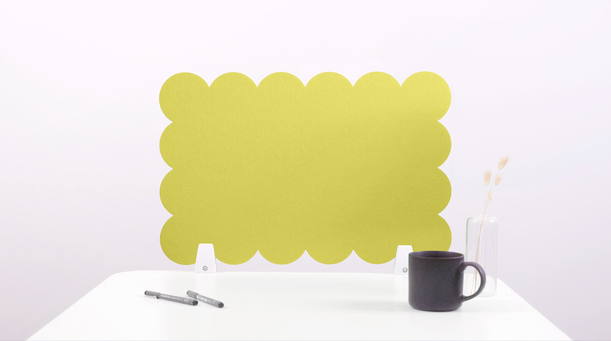 Yellow scalloped screen on a white surface with a black mug and pen holder.