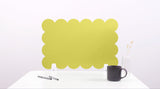 Yellow scalloped screen on a white surface with a black mug and pen holder.
