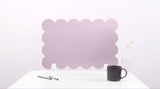 Pink bubble-shaped screen on a white surface with a black mug and pen.