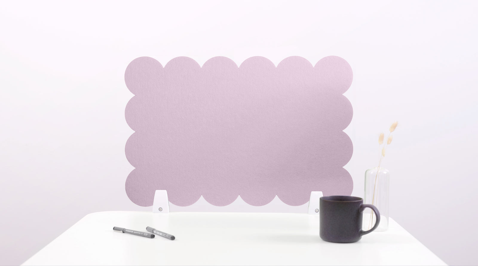 Pink bubble-shaped screen on a white surface with a black mug and pen.