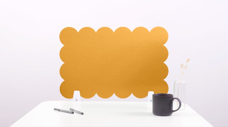 Yellow scalloped placemat on a white surface with a black mug and pen.