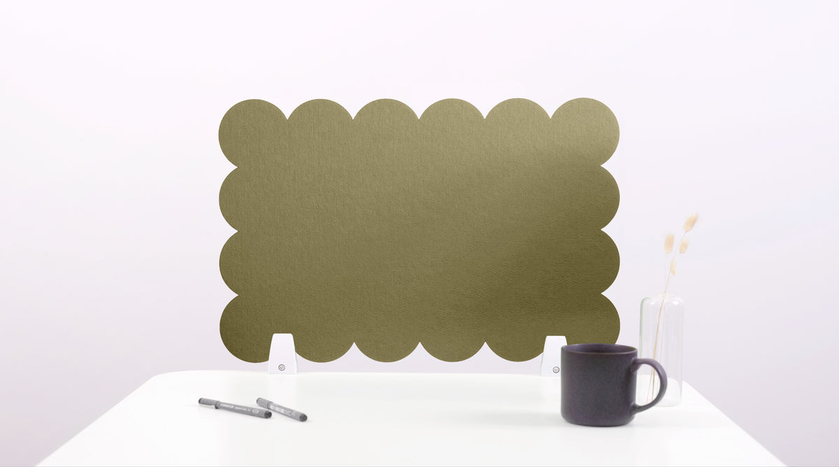 Green scalloped screen on a white surface with a black mug and pen.