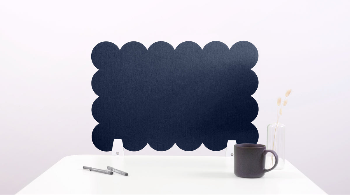 Black cloud-shaped chalkboard on a white surface with a pen and mug.