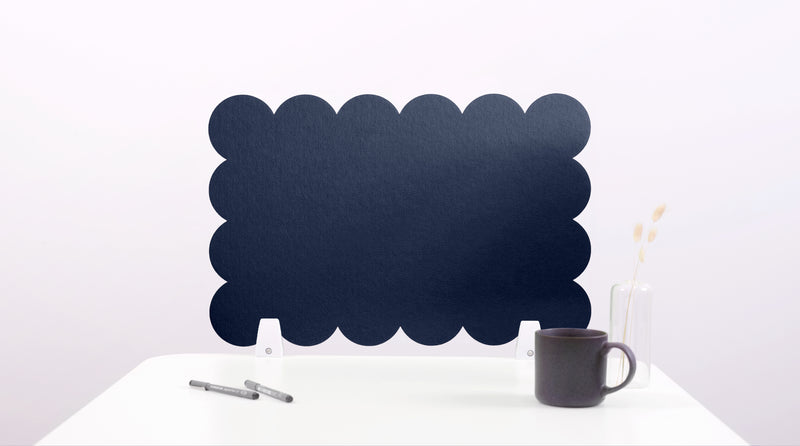 Black cloud-shaped chalkboard on a white surface with a pen and mug.