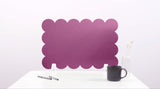 Purple scalloped headboard on a white background with a black mug and pen.
